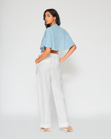 Back view of Carolina blue gingham tie front crop top paired with white linen wide-leg pants showcasing relaxed contemporary styling.