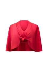 Studio product shot of the front of the vibrant red Carolina Silk Cape Top, showing its unique knotted front design and cropped cape silhouette.