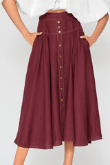 Mid-section product view focusing on the structured waistband, front button-down closures, and fine gathers on the burgundy Patricia linen midi skirt.