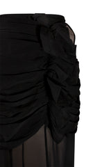 Close-up macro view highlighting the intricate textile details of the black Paulina skirt, showing the dense fabric gather pleats and fluid cascading vertical ruffles.