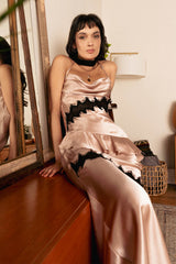 Model seated on a wooden dresser wearing the Cindy Castro New York Vicky Silk Satin Lace Dress.