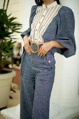 Close-up of Andrea high waisted wide leg denim pants highlighting utility pockets, woven belt, contrast stitching, and refined tailoring.