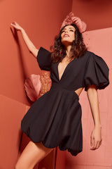 Model wearing the Cameron black bubble mini dress featuring puff sleeves, side cutouts, deep V-neck, and voluminous bubble skirt.