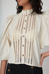 Detailed close-up view of the front placket, showcasing the intricate geometric open-work lace embroidery on the cream cotton Eva blouse.