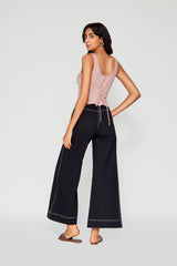 Rear studio perspective of a model showing the scoop neck back configuration and delicate striped lace-up ties on the Ines bustier top.