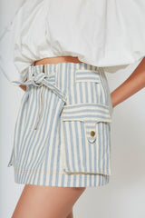 Close-up of the Mati Denim Skirt highlighting blue stripe fabric, cargo pocket, front zipper, and adjustable waist tie details.