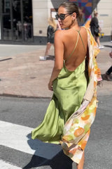 Street style featuring the Vanessa Slip Dress in kiwi satin with delicate spaghetti straps, open back, graceful movement, and timeless elegance.