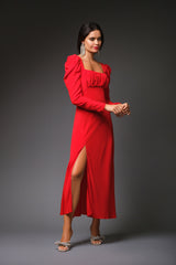 Three-quarter studio portrait of a woman modeling the red Cindy silk gown, highlighting the gathered bustier-style square neckline and a thigh-high front leg slit.