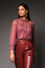 Three-quarter studio portrait highlighting the upper yoke details of the mauve Martha blouse, featuring delicate floral lace paneling along the collar and chest with a hidden button-down placket.