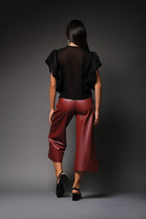 Rear studio perspective of a model displaying the smooth, sheer black chiffon back panel and delicate ruffled cap sleeve trim of the Miranda blouse.